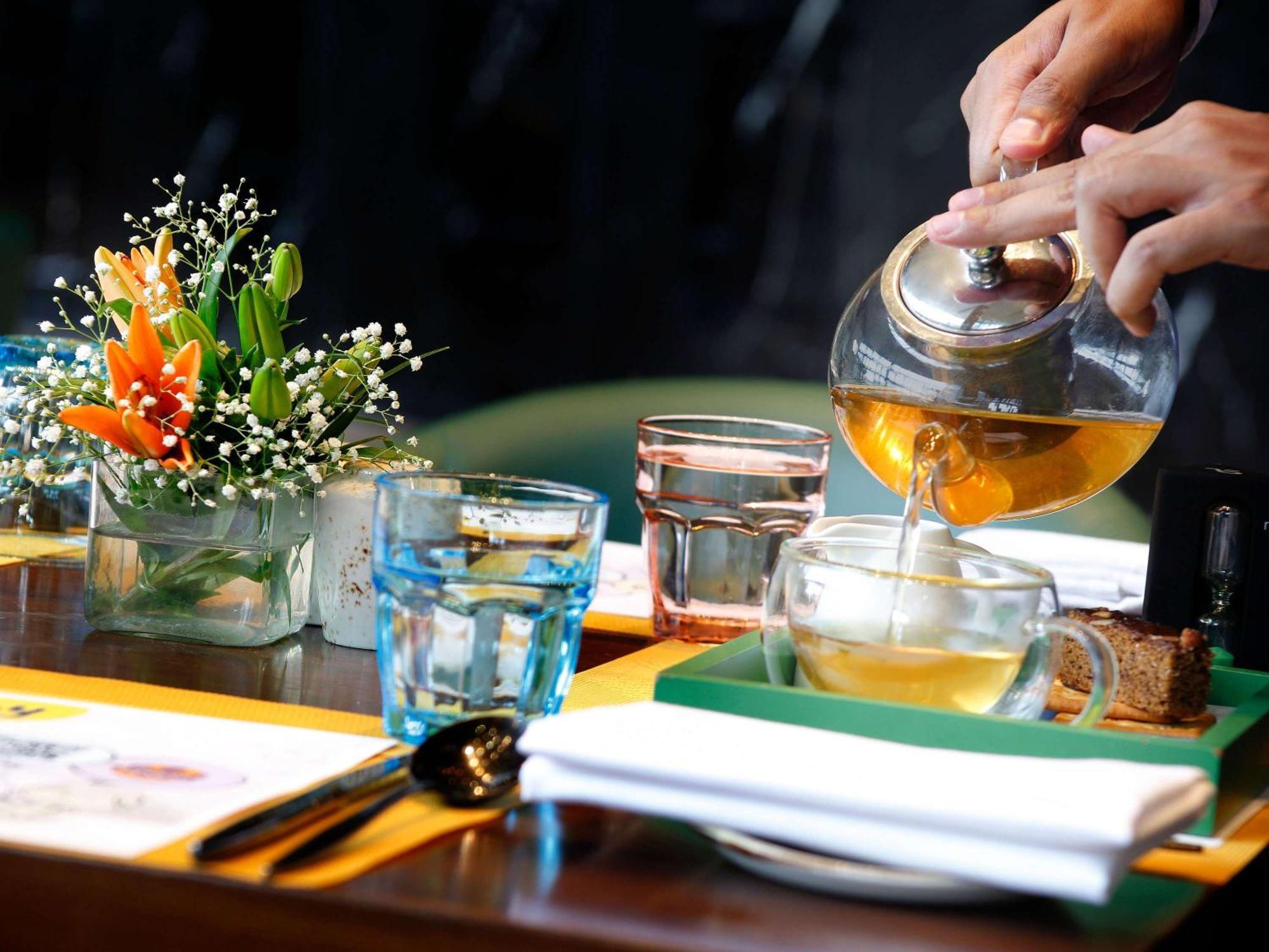 Novotel Kolkata Hotel And Residences Extérieur photo A server pours tea at a restaurant