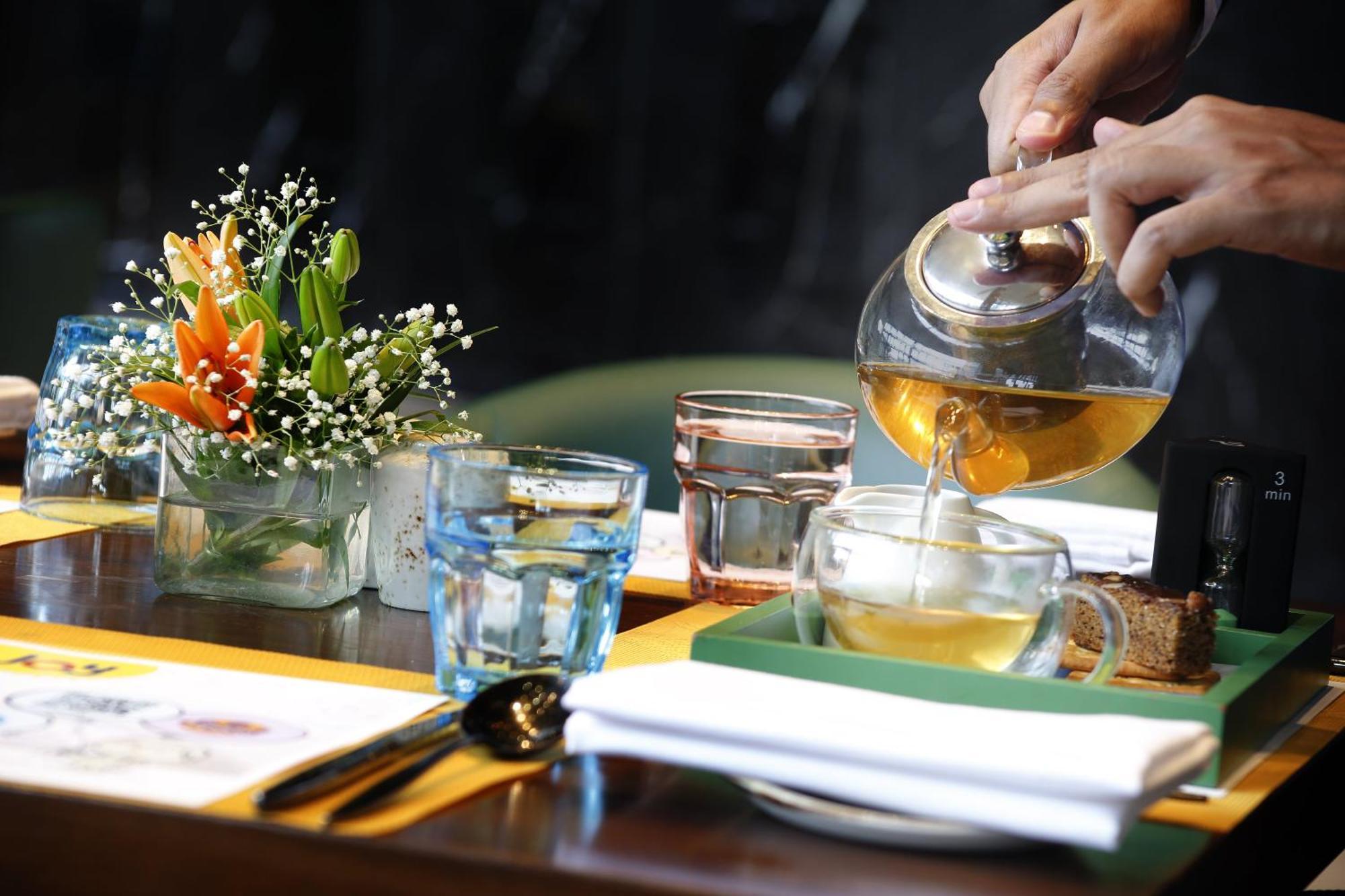 Novotel Kolkata Hotel And Residences Extérieur photo A server pours tea at a restaurant